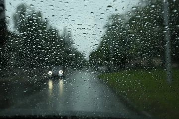 Foto op Aluminium Blurred view of road through wet car window. Rainy weather © New Africa