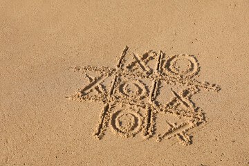 Tic tac toe game drawn on sandy beach