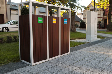 Different sorting bins for waste recycling on city street outdoors