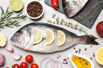 Flat lay composition with fresh raw dorado fish and ingredients on light grey table