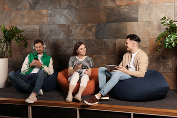 Office employees enjoying break together in recreation room at work