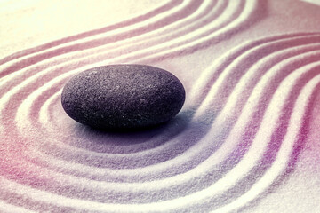 Fototapeta na wymiar Grey stone on sand with pattern. Zen, meditation, harmony