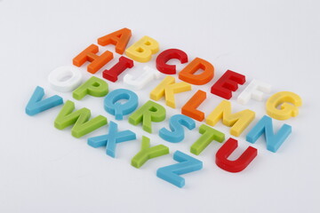 Plastic alphabet letters laid out on a white surface