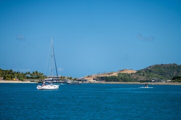 tourist boats and tour boats in the whitsundays queensland, australia. travellers on the great barrier reef, over coral and fish. tourism yachts of young people partying on the water