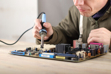 precise soldering of the computer motherboard on the table