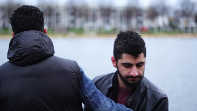 Two young middle eastern men hugging each other and saying goodbye
