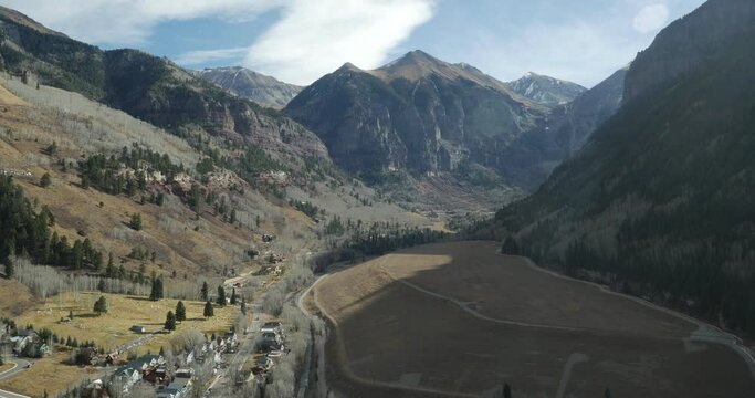 High aerial above town of Telluride, Colorado with Black Bear Pass in distance