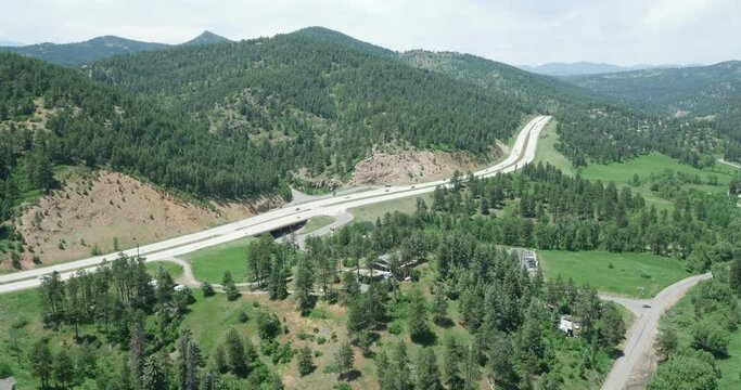 Aerial tilting up to forested mountain Highway 285 in Conifer, Colorado in summertime