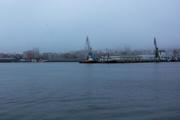 Obraz premium A commercial port for ships in the city in heavy fog views from the water.