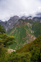 Hiking path (the high road) of Tiger Leaping Gorge. Travelers hiking in the mountains. Located 60 kilometres north of Lijiang City, Yunnan Province, China. Vertical image