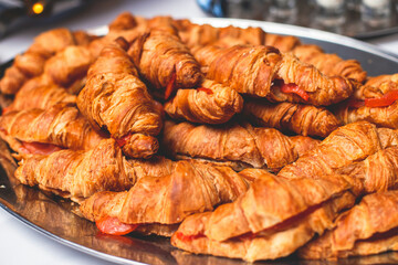 Catering table, beautifully decorated banquet table with variety of different food snacks, sandwiches, croissants and appetizers on party event or celebration, delicatessen setting, coffee break