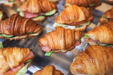 Catering table, beautifully decorated banquet table with variety of different food snacks, sandwiches, croissants and appetizers on party event or celebration, delicatessen setting, coffee break