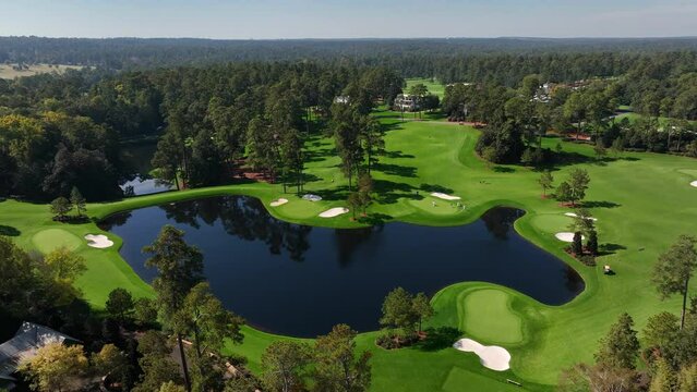Spruce pine trees at Augusta National Golf Club in Georgia. Aerial view of water hazard and sandtraps on fairway greens.