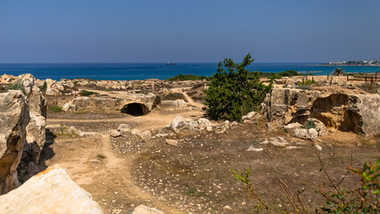 Carved tombs and graves with ocean in distance, Paphos, Cyprus