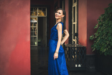 Beautiful asian model wearing in blue dress posing in a rich interior.