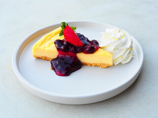 Traditional classic cheesecake serving with whipping cream and fresh blueberry. Famous sweet dessert menu in coffee and bakery shop.