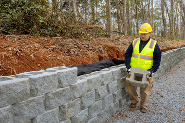 In part of construction project that is building retaining walls on new site contractor installing...