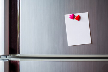 Abstract of wooden heart clip with Blank paper and stick paper on refrigerator door. paper note copy space for add text. valentine picture message background