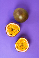 Sliced passion fruit. Fresh passion fruit on a purple background. Selective focus.