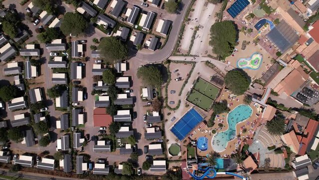 Aerial top down shot of campsite with apartments, swimming pool and sport fields in summer