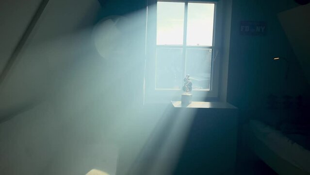 
Rays of the sun seeping through the window into the boy's dark room