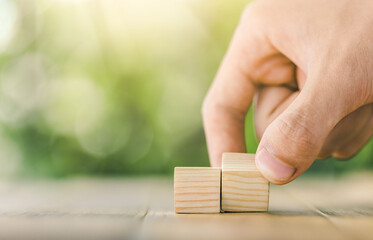 Hand arranging wood block stacking as step stair on wooden table. Business concept for growth success process. Copy space.