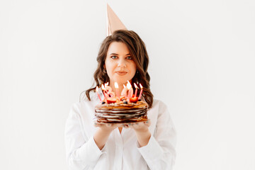 a funny woman with a birthday cake with candles.