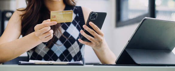 Woman hands holding and using cradit card for shopping online.