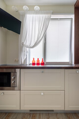 Details of a cozy well -thought -out modern kitchen interior with red bottles