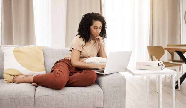Relax, laptop and woman on a sofa in a living room for news, social media or streaming in her home. Black woman, couch and online search for educational study, upskill and training tools in Africa