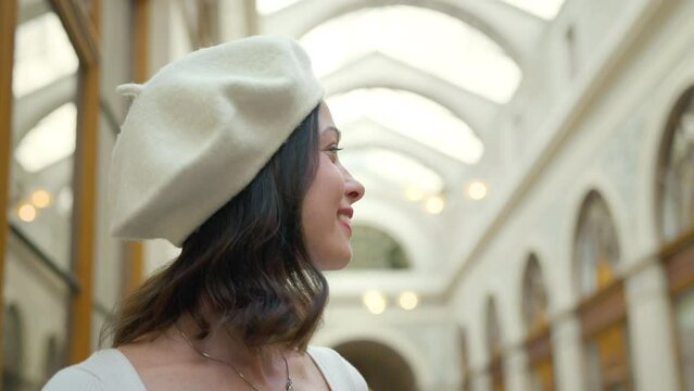 Portrait of a smiling girl in a white beret in a Parisian museum