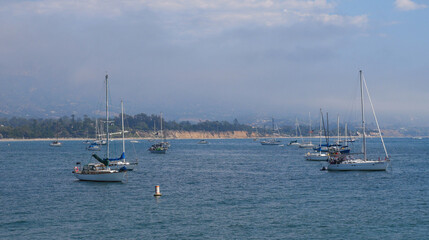 Fototapeta premium Sailboats standing in front of the coast of Santa Barbara, California, near Stearns Wharf.
