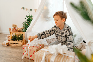 A little boy lying in a children's wigwam decorated for Christmas © fotofabrika