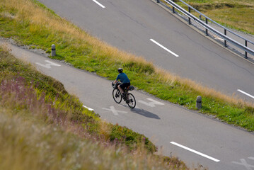 Obraz premium Aerial view of mountain pass road and tour cyclist at Swiss mountain pass Oberalppass on a late summer day. Photo taken September 5th, 2022, Oberalp Pass, Switzerland.