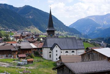 Scenic view of mountain village Rueras, Canton Graubünden, with church on a blue cloudy late summer day. Photo taken September 5th, 2022, Rueras, Switzerland.