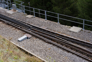 Railway track of narrow gauge railway at Swiss mountain pass Oberalppass on a blue cloudy late...
