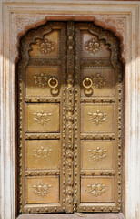 Floral patterns and carvings on the entrance metal doors of the ancient City Palace in Jaipur, India. Beautiful floral paintings in the ancient palace.