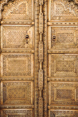 Floral patterns and carvings on the entrance metal doors of the ancient City Palace in Jaipur, India. Beautiful floral paintings in the ancient palace.