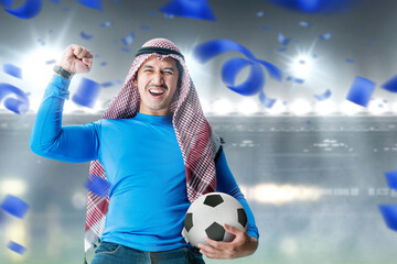 Asian man with keffiyeh standing while holding the ball with an excited expression