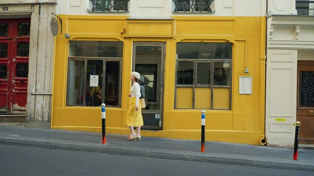 Young tourist in a yellow skirt walking through the streets of Paris