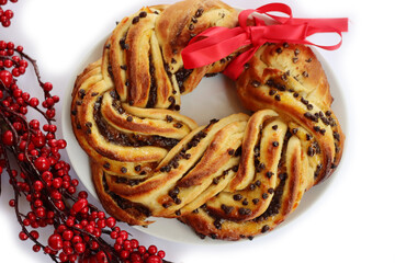 Chocolate and orange jam braided Brioche bread wreath isolated on white background with Christmas...