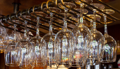 Fototapeta na wymiar Shiny wine glasses hanging on a metallic structure in a bar, Paris, France.