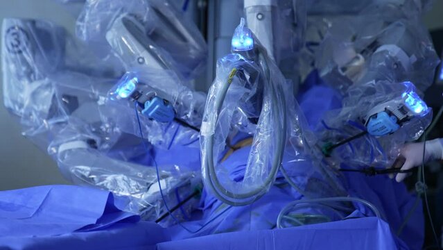 Numerous arms of robotic surgery equipment covered in plastic. Technological modern apparatus performing minimal invasion surgery.