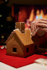 Building and decorating a christmas gingerbread house.