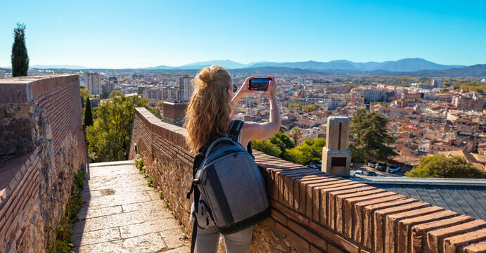 Woman tourist taking photography at Girona,  panoramic view of the city- Spain