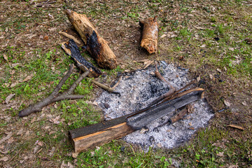 Ashes from a campfire in nature. Close up view of the extinct bonfire in a dry grass, abandoned...