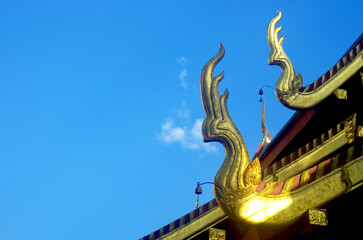Fototapeta na wymiar The roof of the Thai ubosot has a naga head gable in Thai art. The roof of the church in a Thai temple.