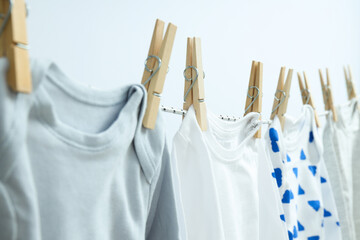 Child clothes hanging and drying on twine on light background