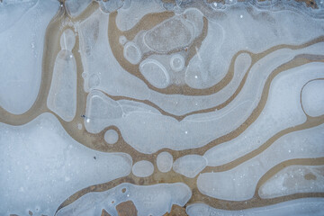 Snow covered pattern of frozen water in a puddle.