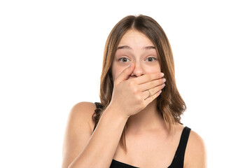 Fototapeta premium Shocked Embarrassed Young Woman Covering Mouth On A White Background